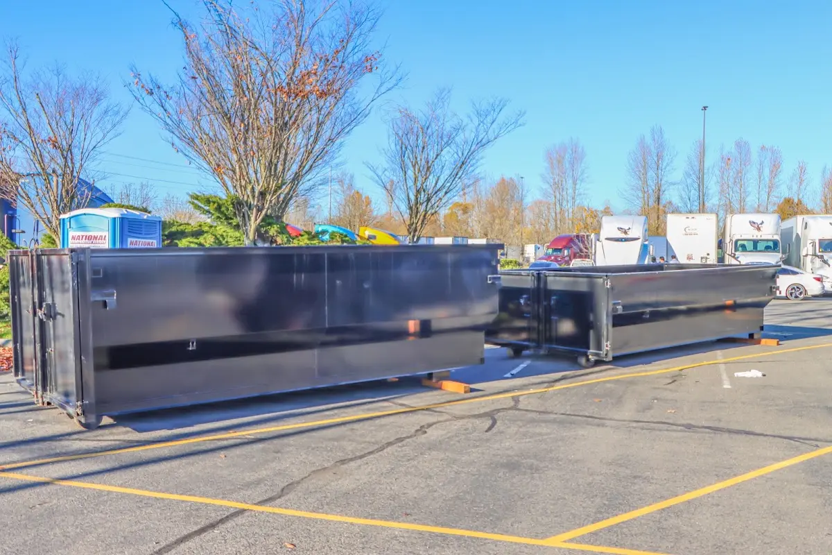 Professional dumpster rental service with roll-off container on residential driveway in North Elba